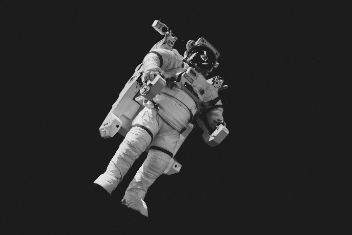 astronaut in white suit in grayscale photography
